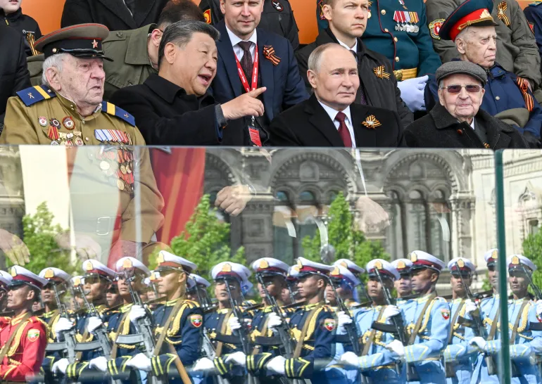 Russian President Vladimir Putin, centre right, and Chinese President Xi Jinping, centre left, talk as Myanmar’s servicemen are reflected in glass, during the Victory Day military parade in Moscow, Russia, on May 9, 2025 [Sergei Bobylev/RIA Novosti via AP]