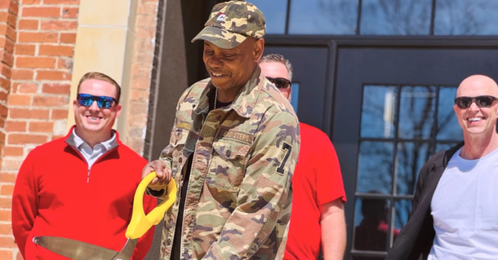 The comedian stood outside the freshly restored 19th-century schoolhouse on Thursday, alongside local residents and officials, as a community radio station celebrated securing its long-term future in the town he calls home. (AP Video Patrick Aftoora-Orsagos)
